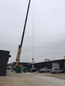 Crane lifting HVAC unit off of the ground in Dallas, Tx.