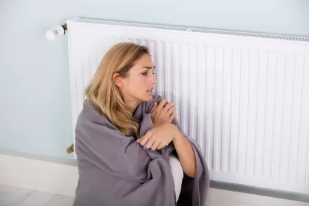 Woman cold and in need of heating repairs in Dallas, TX
