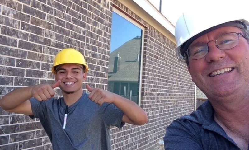 Two Texas Aces technicians smiling at the camera during HVAC install in Dallas, TX.