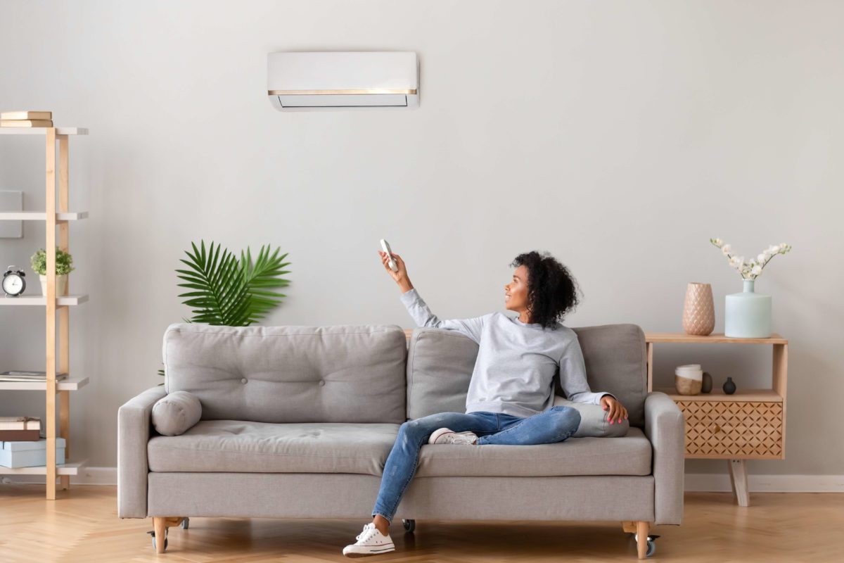 Woman with remote controlled air conditioning